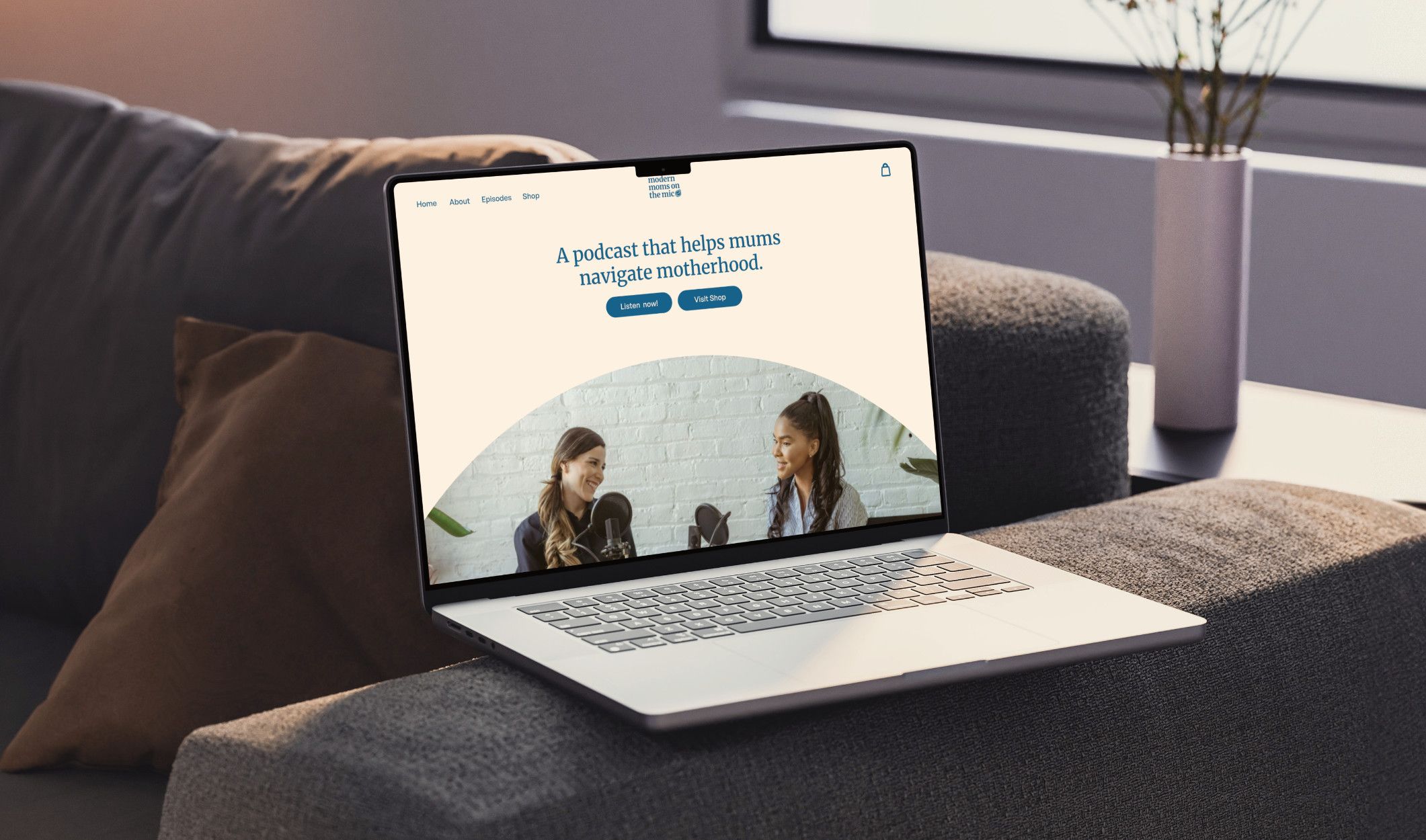 Laptop on a couch with a website design for a podcast brand